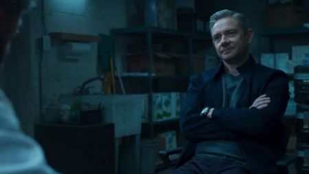Everett Ross folding his hands while interrogating